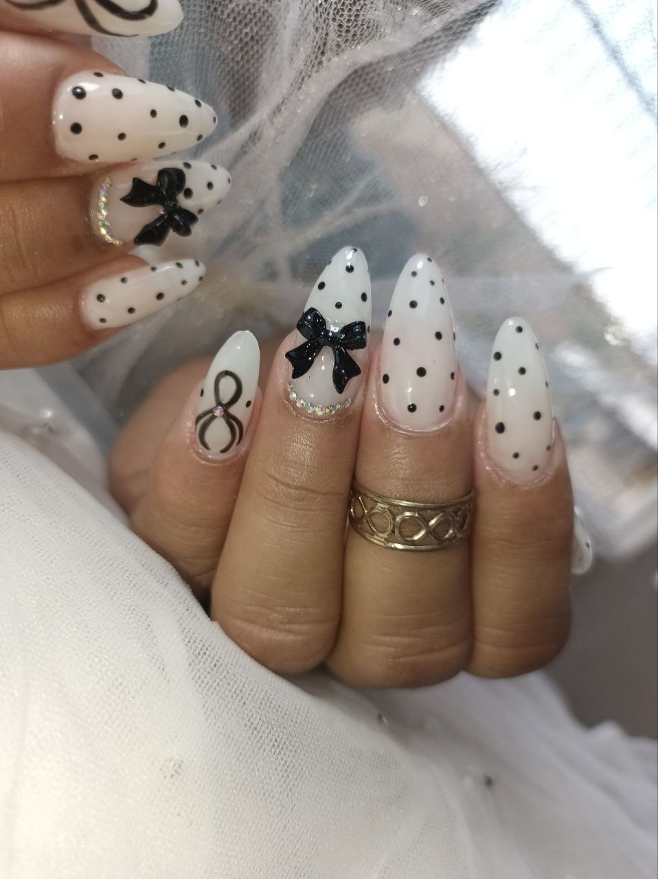 Uñas con diseño en blanco y negro y lazos 3D